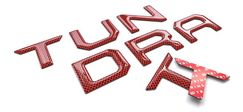 Pu&ograve; includere: Lettere 3D rosse che compongono la parola "Tundra" con un motivo in fibra di carbonio. Le lettere sono vendute singolarmente e sono progettate per essere utilizzate come sostituzione delle lettere di fabbrica di una Toyota Tundra.