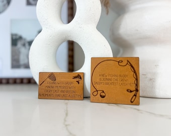 May include: Two wooden plaques with engraved fishing-themed messages. The first plaque reads "Fishing with Daddy - Making memories with every cast and reeling in moments that last a lifetime." The second plaque reads "A new fishing buddy is joining the crew - Daddy's greatest catch yet!"