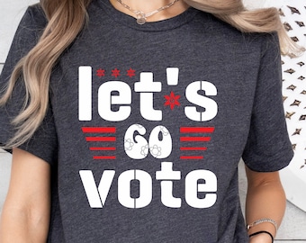May include: A dark gray t-shirt with the text "Let's Go Vote" in white with red stars and stripes.