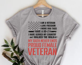 May include: Gray t-shirt with a black and white American flag graphic and red text that reads "I am a Veteran, I love Freedom, I wore dog tags, I have a DD-214, I have served my country, I walked the walk, My oath never ends, Proud Female Veteran".