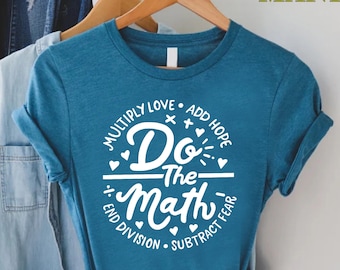 May include: Teal blue t-shirt with white text that reads "Multiply Love, Add Hope, Do The Math, End Division, Subtract Fear".