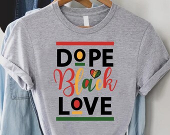 May include: Gray t-shirt with the text "Dope Black Love" in black, red, yellow, and green. The text is surrounded by red, yellow, and green stripes.