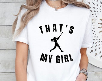 May include: White t-shirt with black text that reads "That's My Girl" and a silhouette of a girl playing baseball.