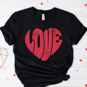 May include: Black t-shirt with a red heart-shaped graphic that says "LOVE" in a retro font.