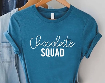 May include: A teal blue t-shirt with white text that reads "Chocolate Squad".