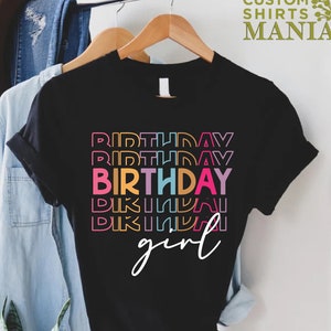 May include: Black t-shirt with the text "Birthday girl" in rainbow colours. The text is stacked with the word "Birthday" repeated multiple times.