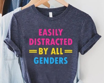 May include: A dark blue t-shirt with the text "Easily Distracted By All Genders" in pink, yellow, and blue.
