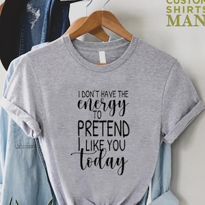 May include: Grey t-shirt with black text that reads "I don't have the energy to pretend I like you today."