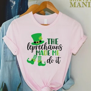May include: Pink t-shirt with a green leprechaun graphic and the text "The Leprechauns Made Me Do It".