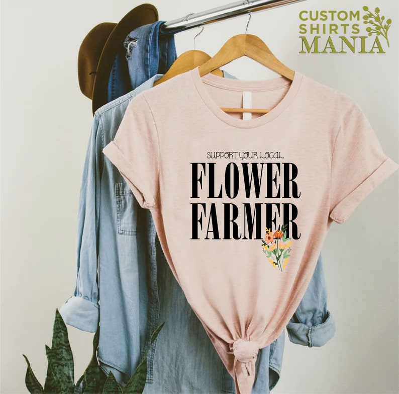 May include: A pink t-shirt with the text "Support your local Flower Farmer" in black lettering and a small floral design.