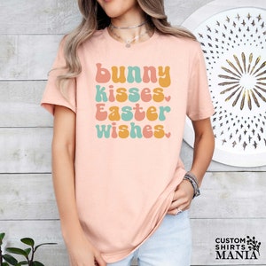 a woman wearing a pink t - shirt that says bunny kisses easter wishes