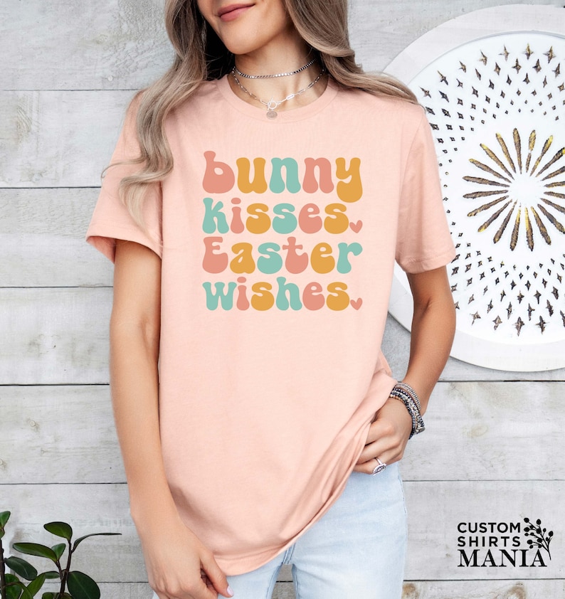 a woman wearing a pink t - shirt that says bunny kisses easter wishes