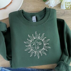 a green sweatshirt with a sun on it