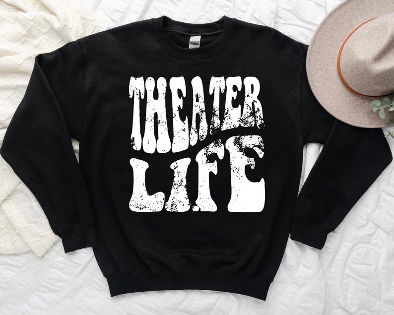 May include: Black sweatshirt with white text that reads "Theater Life" in a retro font.