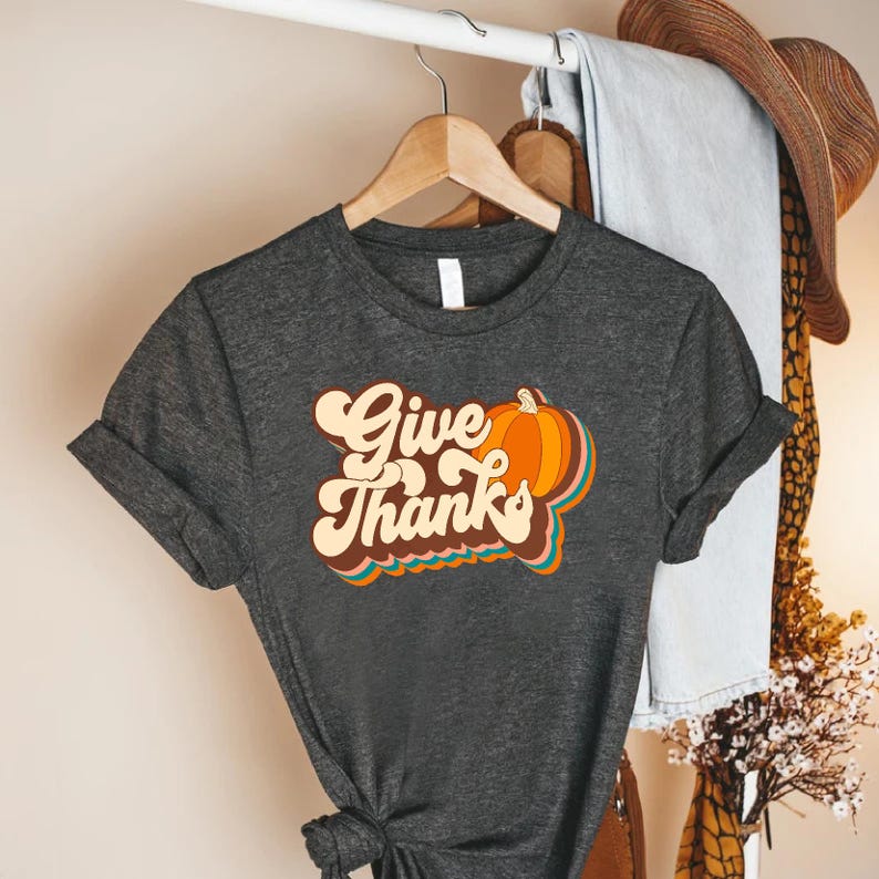 a t - shirt that says give thanks on it
