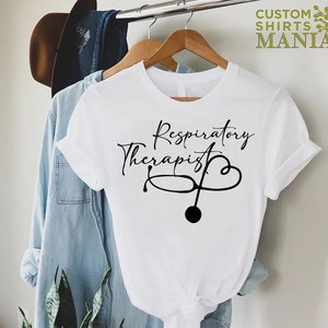 May include: White t-shirt with black text that reads "Respiratory Therapist" and a stethoscope with a heart.