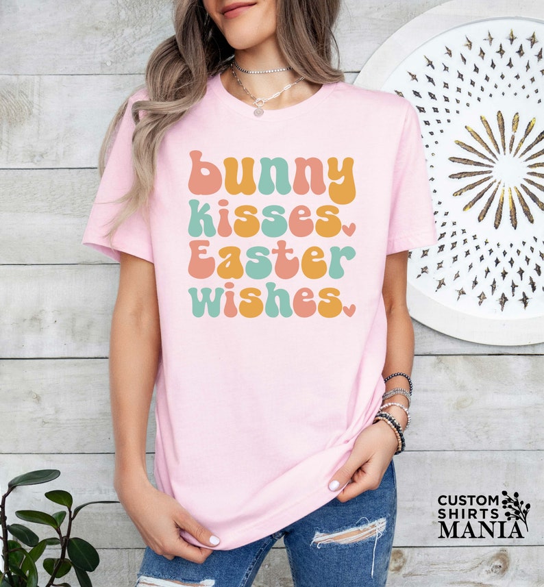 a woman wearing a pink t - shirt that says bunny kisses easter wishes