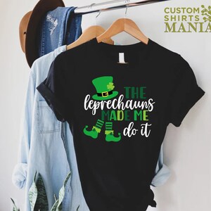 May include: Black t-shirt with a green leprechaun graphic and the text "The Leprechauns Made Me Do It".