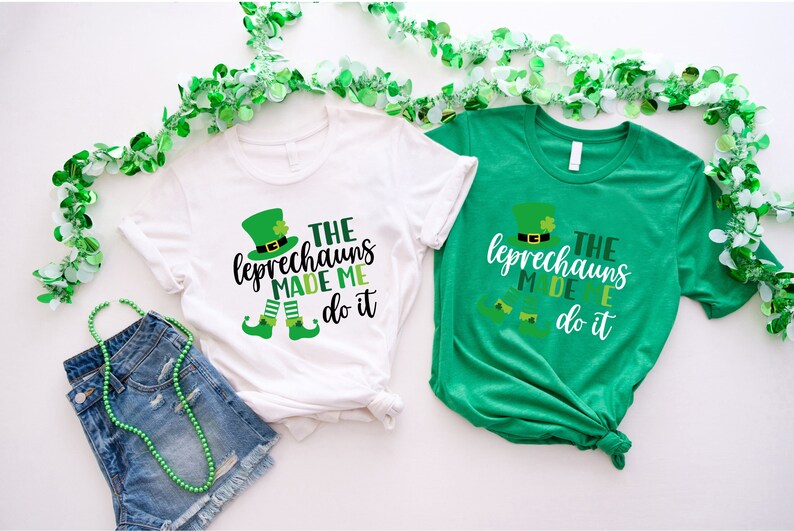 May include: Two white and green t-shirts with a leprechaun graphic and the text "The Leprechauns Made Me Do It".