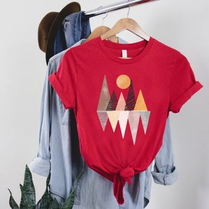 a red t - shirt with a mountain scene on it