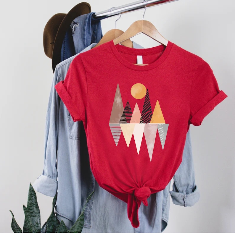 a red t - shirt with a mountain scene on it