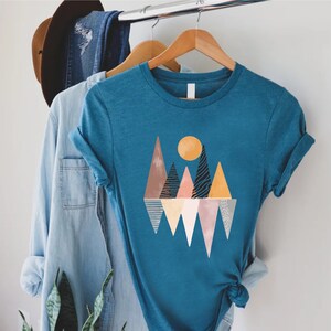 a t - shirt hanging on a clothes rack next to a cactus