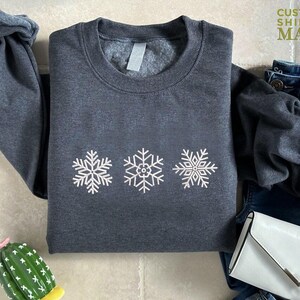 a sweater with snowflakes on it next to a cactus