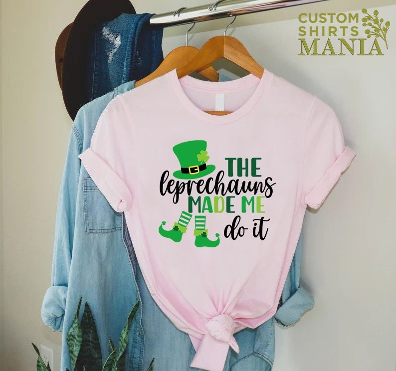 May include: Pink t-shirt with a green leprechaun graphic and the text "The Leprechauns Made Me Do It".