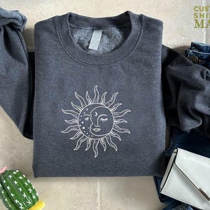 a gray shirt with a sun and moon on it