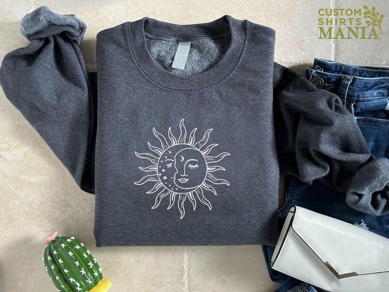 a gray shirt with a sun and moon on it