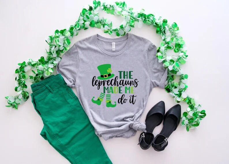 May include: A gray t-shirt with a green leprechaun graphic and the text "The Leprechauns Made Me Do It".