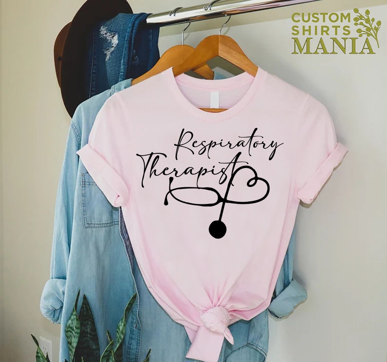 May include: Pink t-shirt with black text that reads "Respiratory Therapist" and a stethoscope with a heart graphic.