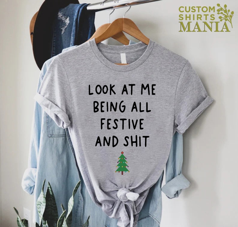 May include: Gray t-shirt with the text "Look at me being all festive and shit" and a small green Christmas tree graphic.
