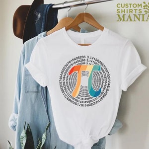 Może przedstawiać: Biały t-shirt z wzorem w kształcie tęczy, przedstawiającym stałą matematyczną pi (&pi;) i cyfry pi w układzie kołowym.