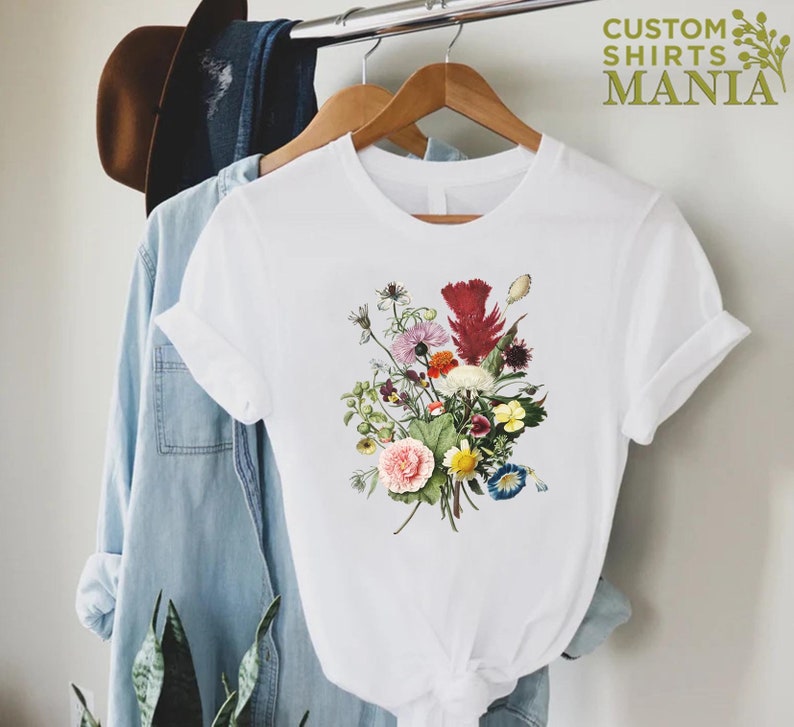 a white t - shirt with a bouquet of flowers on it