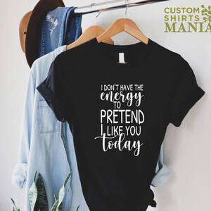 May include: Black t-shirt with white text that reads "I don't have the energy to pretend I like you today."
