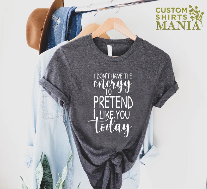 May include: A dark grey t-shirt with white text that reads "I don't have the energy to pretend I like you today".