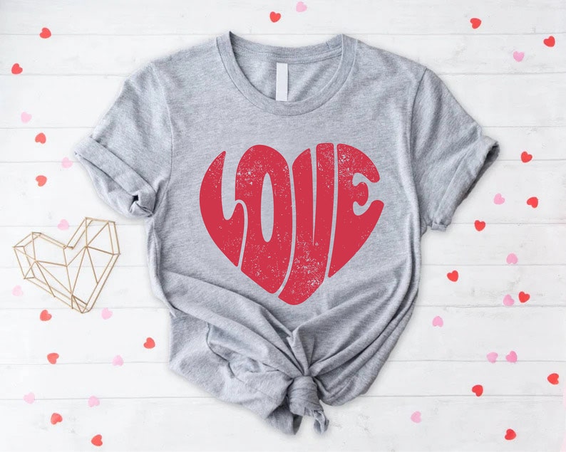 May include: A gray t-shirt with a red heart-shaped graphic that says "LOVE" in a vintage style font.