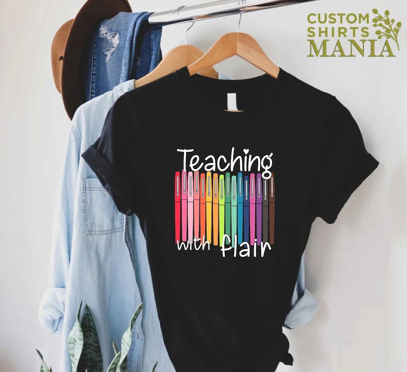 May include: Black t-shirt with the text "Teaching with Flair" and a rainbow of colorful markers.