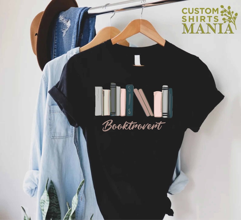 May include: Black t-shirt with a graphic of a stack of colorful books and the text "Booktrovert".