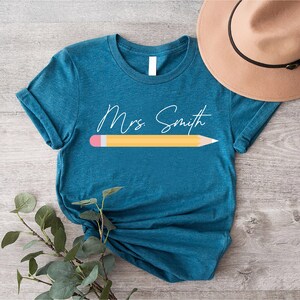 a t - shirt with a pencil on it and a hat