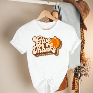 a white t - shirt that says give thanks on it