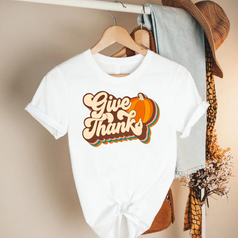 a white t - shirt that says give thanks on it