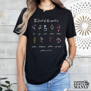 a woman wearing a black t - shirt with flowers on it