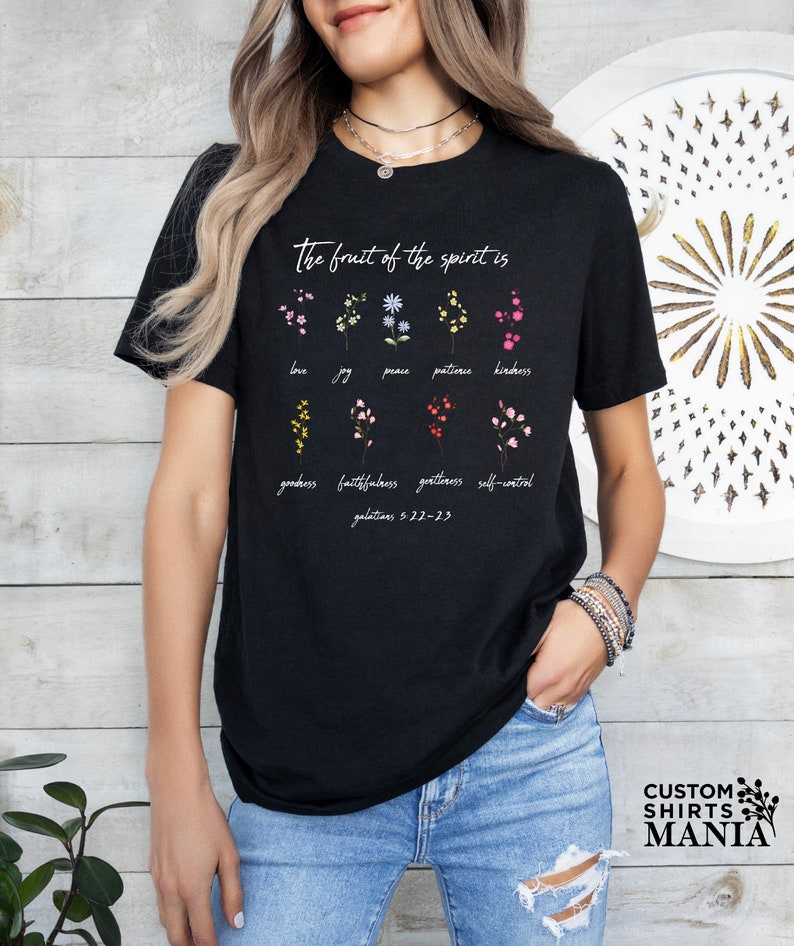 a woman wearing a black t - shirt with flowers on it