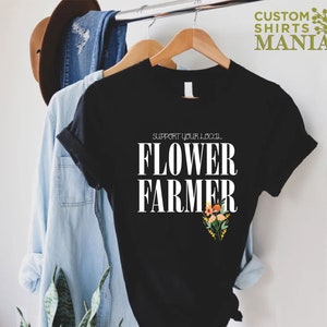 May include: Black t-shirt with white text that reads "Support your local Flower Farmer" and a small floral design in orange, yellow, and pink.