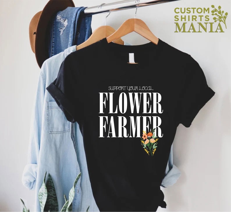 May include: Black t-shirt with white text that reads "Support your local Flower Farmer" and a small floral design in orange, yellow, and pink.