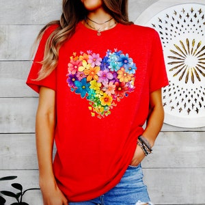 a woman wearing a red t - shirt with colorful flowers on it