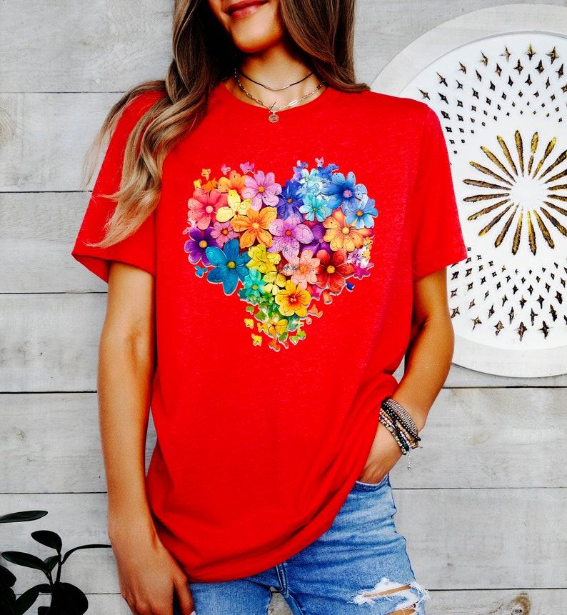 a woman wearing a red t - shirt with colorful flowers on it