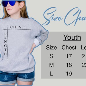 May include: Size chart for youth sweatshirts with measurements in inches for chest and length. Sizes include S, M, and L. The chart shows a model wearing a gray sweatshirt with the measurements marked.